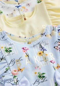 Due vestitini per bambini piegati, uno di colore giallo pallido e uno azzurro chiaro con stampe floreali, farfalle e testo dorato "BAKER" su tessuto morbido.