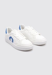 Zapatillas deportivas blancas con un acento azul en el talón, material sintético suave, cierre de cordones y un diseño de puntera redondeada.