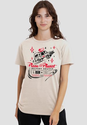 Woman wearing beige t-shirt with "Pizza Planet Delivery Shuttle" graphic of a flying delivery truck and space-themed red and black accents.