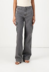 Gray cargo pants with a relaxed fit, featuring multiple side pockets, denim texture, and a slightly faded finish.