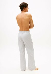 Gestreepte pyjamabroek met een elastische tailleband in een lichtgewicht stof. De kleuren zijn wit en blauw, met een rechte pijp.