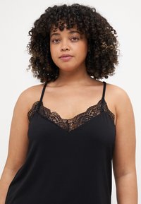 Schwarzes Top mit Spitzendetails am Ausschnitt, verstellbaren Spaghetti-Trägern und einer weichen, glatten Textur.