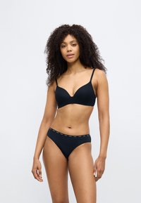Sort BH med tynde justerbare stropper og en dyb udskæring, kombineret med matchende sorte trusser med en branded linning. Blødt materiale.