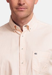 Licht perzik kleurige button-up shirt van stof met een gestructureerd oppervlak. Voorzien van een button-down kraag, een zak met logo en contrasterende knopen.
