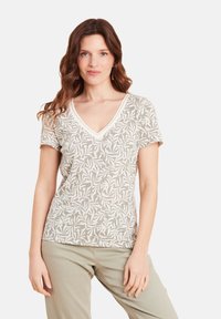 Lichtgrijze t-shirt met een V-hals, korte mouwen en een wit bladdessinpakket. Zachte stof met een relaxte pasvorm.