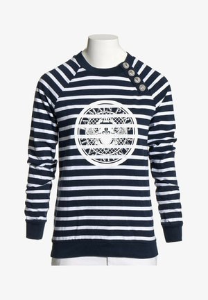Chemise à manches longues rayée bleu marine et blanc avec quatre boutons décoratifs sur l'épaule et un emblème circulaire avec texte et blason sur la poitrine.