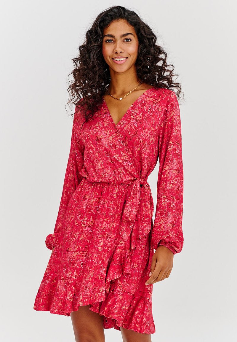 Červené květinové šaty typu wrap s dlouhými rukávy, volánkovým lemem a taženým pasem. Tkanina má jemný, strukturovaný povrch s kombinovaným vzorem.