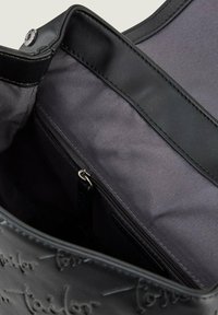 Crna kožna torba za nošenje s teksturiranom površinom, s unutarnjim džepom na patentni zatvarač i mekim sivo-smeškim postavom. Magnetna kopča na vrhu.