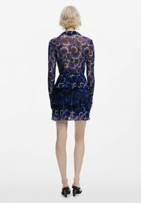 Blumenmusterkleid in tiefblau und gold, durchsichtige lange Ärmel, plissierter Rüschensaum, figurbetontes Oberteil, weiche Textur und geschichtetes Design.