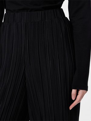 Schwarze plissierte Hose aus strukturiertem Stoff mit einem breiten elastischen Bund. Sichtbare vertikale Falten sorgen für Dimension und Detail.