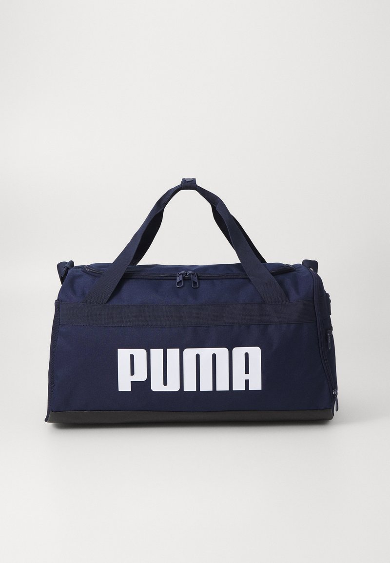 Sac de voyage en toile robuste de couleur marine, doté de deux poignées supérieures, d'une fermeture éclair et d'un grand logo blanc "PUMA" sur le côté.