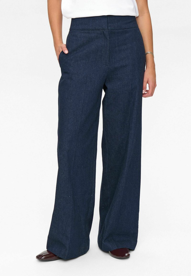 Wide-leg dark denim pants with a high waistband, featuring two side pockets and a smooth texture. Suitable for casual wear.