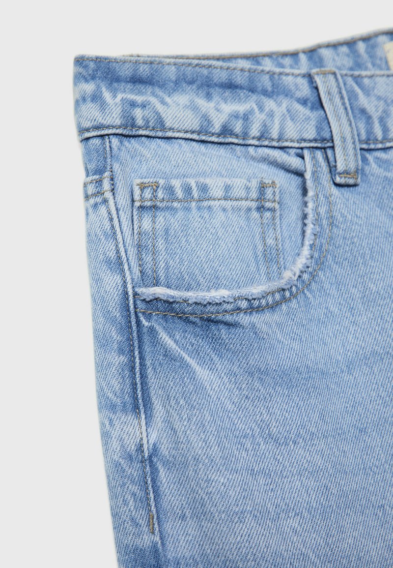 Jeans in denim blu chiaro con una texture consumata, dotati di una piccola tasca posteriore, dettagli cuciti e una vita standard.