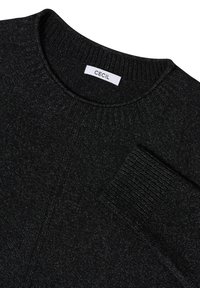 Czarny sweter z materiału dzianinowego z okrągłym dekoltem, ściągaczami na rękawach i subtelną teksturą. Metka mówi "CECIL". Materiał ma gładkie wykończenie.