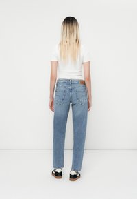 Απαλά μπλε ψηλόμεσα τζιν παντελόνια με χαλαρή καλλιέργεια, που διαθέτουν πίσω τσέπες και καφέ δερμάτινη ετικέτα στη ζώνη.