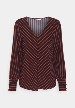 Blouse met lange mouwen en V-hals, diagonale rode en zwarte strepen en manchetten met knopen.