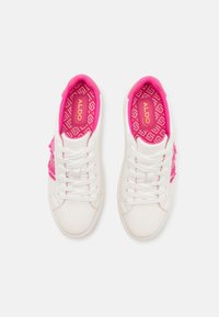 Vita sneakers med rosa detaljer och texturerad design. Har vita skosnören, ett mönstrat innersula och en broderad logotyp på sidan.