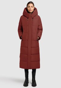 Červený prešívaný kabát s dlhým strihom, oversize kapucňou, zapínaním na zips a patentky, bočnými vreckami a prešívanou textúrou.