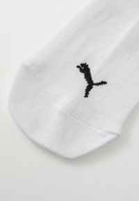 Bijele čarape od pamučnog mješavine, sa crnim Puma logotipom izvezenim sa strane. Mekana tekstura s zaobljenim dizajnom prstiju.
