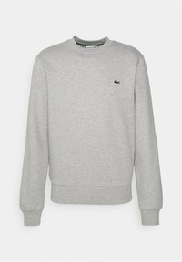 Sweat-shirt gris en tissu doux, avec un col rond, des manches longues et un petit logo vert brodé sur la poitrine.