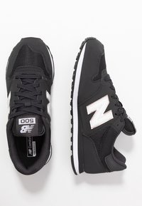 Svarta träningsskor med ovandel i mesh och gummisula. Har en vit logotyp på sidan och en vit accent längs sulatedgen.