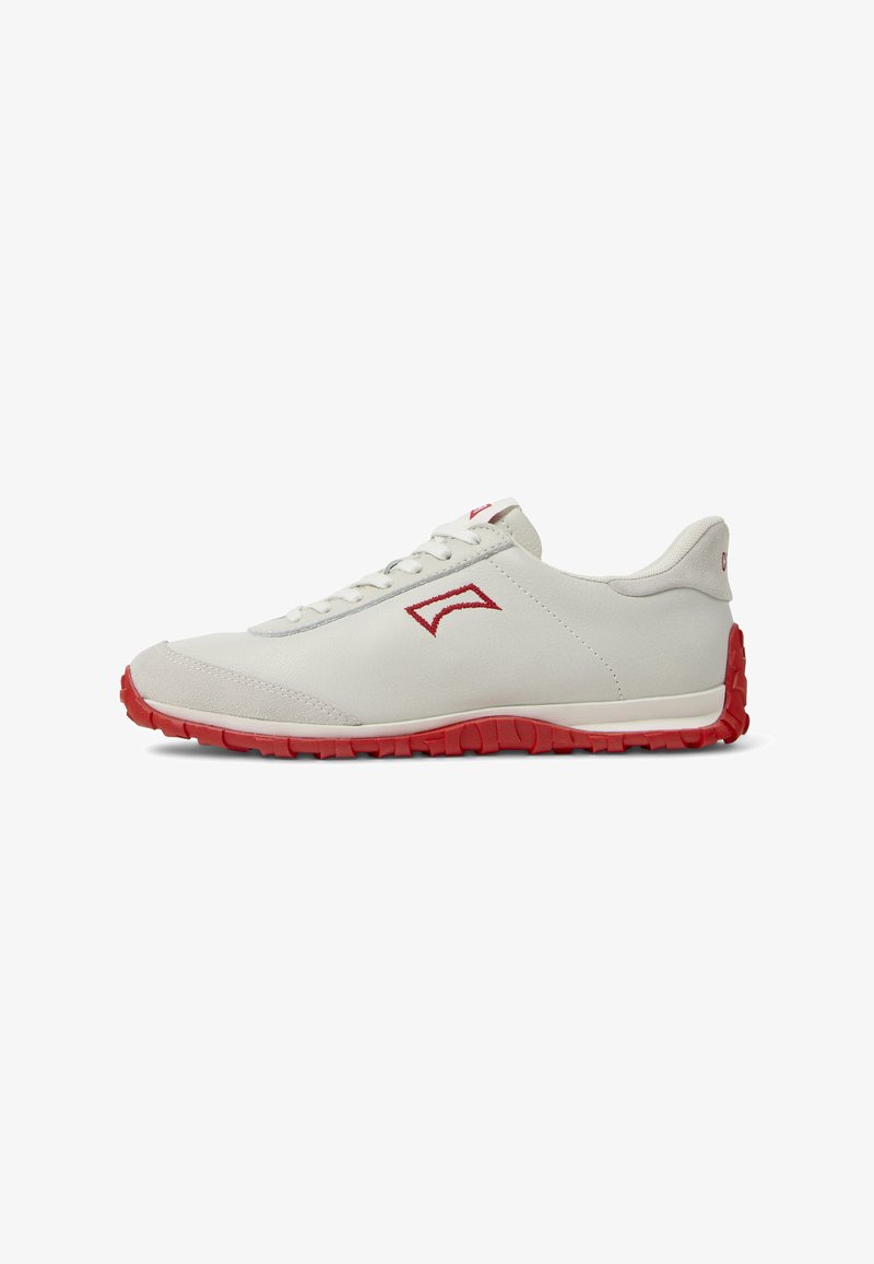 Baskets en cuir gris clair avec semelles en caoutchouc rouge, présentant un design simple, un devant à lacets et des accents minimalistes sur le côté.