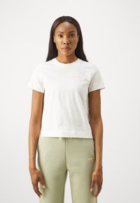 White cotton t-shirt with a round neck, short sleeves, and a cropped fit. Features a subtle pink logo on the left chest area.