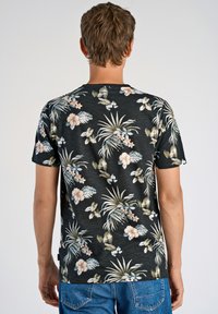 Lyhythihainen musta kukallinen T-paita, jossa on erilaisia vaaleanvärisiä kukkia ja lehtiä, pyöreä pääntie ja pehmeä kangas.