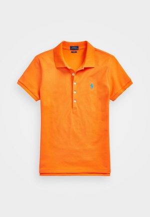 Oranssi puuvillapaita, jossa on klassinen kaulus, lyhyet hihat, viiden napin vetoketju ja sininen insignia rinnassa.