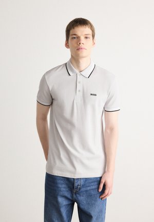 Šviesiai pilkos spalvos polo marškiniai su juodu apvadu ant apykaklės ir rankovių, su trimis mygtukais priekyje ir juodu išsiuvinėtu logotipu krūtinėje.