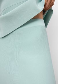 Ljusblå tvådelad outfit med ribbad textur. Toppen är något oversized, medan byxorna sitter åtsittande.