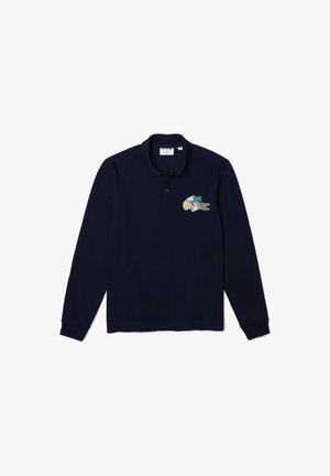 Marineblaues langärmeliges Poloshirt mit Kragen und Knopfleiste, mit einem kleinen bunten bestickten Aufnäher auf der linken Brust.