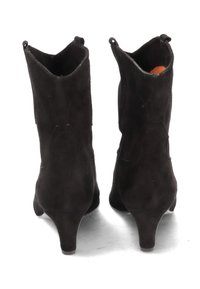 Black suede ankle boots with a slender heel, rounded toe, and shaped openings at the top, featuring subtle stitching details.