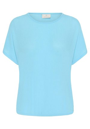Blouse bleu clair à manches courtes, col rond et coupe ample, avec une petite étiquette de marque en tissu à l'intérieur du col.