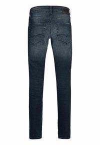 Tmavě modré úzké džíny s kapsami na zadní straně a černou značkovou nášivkou na pasu, zobrazené zezadu.