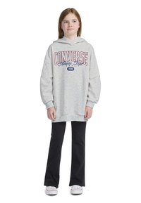 Fleece cinza com a graphic "CONVERSE Athletic Dept.", mangas longas e um corte relaxado, combinado com calças largas pretas e ténis brancos.