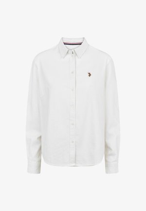Camicia bianca con colletto a punta, maniche lunghe e un'emblema ricamato sul lato sinistro del petto. Realizzata in tessuto leggero.