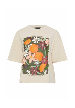 Beige shirt met korte mouwen, bedekt met een kleurrijke bloemen- en oranje fruitprint, met de tekst "Golden Hour" boven en "Growing Wild" onder het ontwerp.