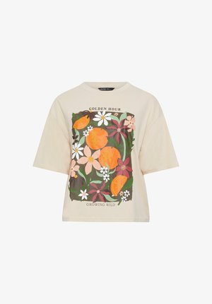 Beige shirt met korte mouwen, bedekt met een kleurrijke bloemen- en oranje fruitprint, met de tekst "Golden Hour" boven en "Growing Wild" onder het ontwerp.