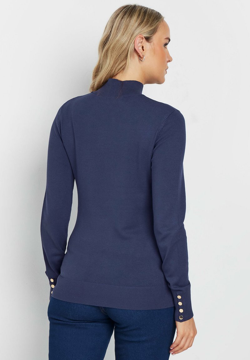 Navy-blauer Langarmpullover mit Stehkragen, geripptem Saum und Knopfdetails an den Ärmeln. Hergestellt aus einem glatten, leichten Stoff.