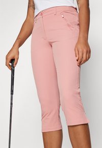 Rosa croppede bukser laget av lett stoff, med en jevn tekstur, glidelåslommer og en tettsittende design som slutter rett under kneet.