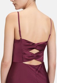 Bordeaux Satin-Kleid mit überkreuztem Rückendesign und Ausschnitten. Die Träger sind dünn und mit verstellbarem Beschlag für eine perfekte Passform.
