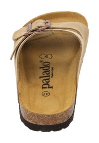 Sandal de color beige claro con plantillas de corcho, tira de ante y hebilla metálica ajustable. Logo impreso en la plantilla, suela texturizada para agarre.
