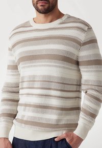 Gestrickter Pullover in Creme und Braun mit horizontalen Streifen. Strukturiertes Design mit abwechselnd festen und offenen Mustern. Runder Halsausschnitt.