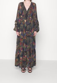 Robe longue en tissu noir transparent avec des motifs de feuilles colorées, décolleté en V profond, manches longues à volants et jupe à étages.