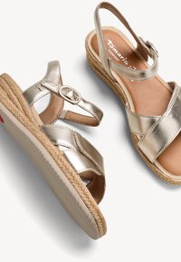 Sandales compensées pour femmes en cuir doré métallisé avec bride cheville, boucle, semelle intermédiaire en jute tressée et semelle intérieure rembourrée.