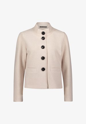 Hellbeige Jacke mit hohem Kragen, fünf schwarzen Knöpfen auf der Vorderseite und zwei frontalen Taschen. Strukturiertes Gewebe mit glatter Oberfläche.