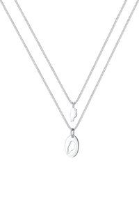 Deux colliers en argent délicats empilés. Le haut présente un pendentif en silhouette d'oiseau, le bas un pendentif ovale avec une gravure d'oiseau.