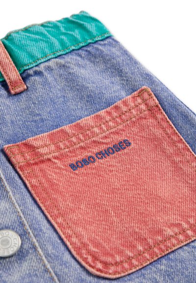 Shorts en denim avec une ceinture multicolore ; corps bleu clair, poche arrière rose avec "BOBO CHOSES" brodé en bleu.