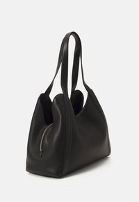 Černá texturovaná kožená taška přes rameno s dvojitými dlouhými uchy a viditelným zlatým zipem na boku, vyfotografovaná na bílém pozadí.